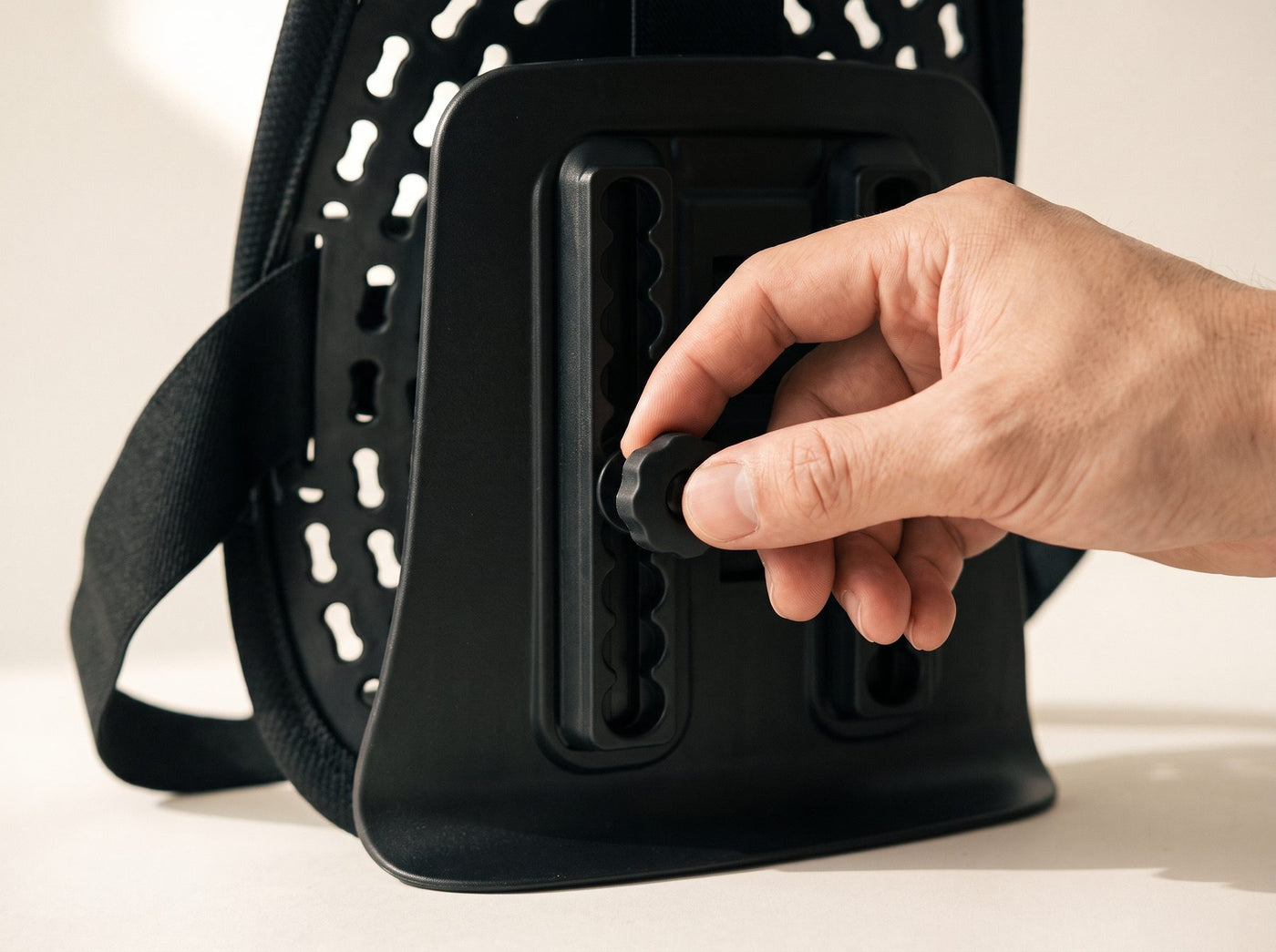 A hand turning the knob on the four position height track